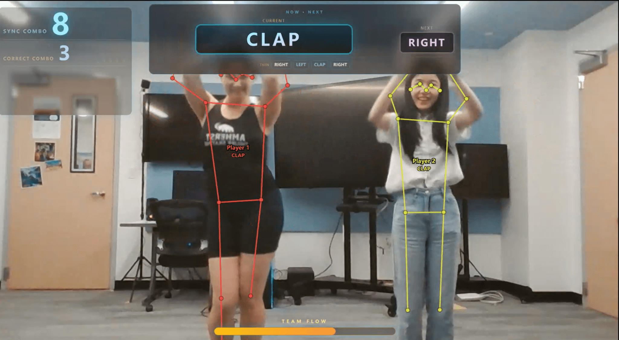 Two dancers perform in front of a camera while pose overlays and group synchrony feedback appear on screen.
